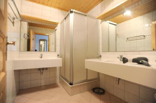 La salle de bains est pourvue de 2 lavabos, d'une douche et d'un miroir. dans l'établissement Chalet Alice by Schladmingurlaub, à Schladming