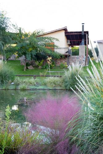 a garden with a pond in front of a house at Aguilas de Piedra in Cacheuta
