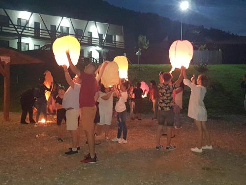 a group of people holding up lanterns at night at Hotel Class in Brezoi