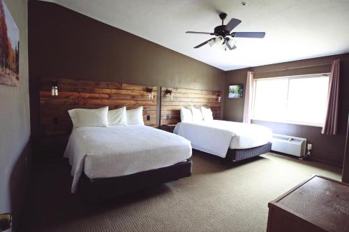 a hotel room with two beds and a ceiling fan at Hidden Canyon Retreat in Baker