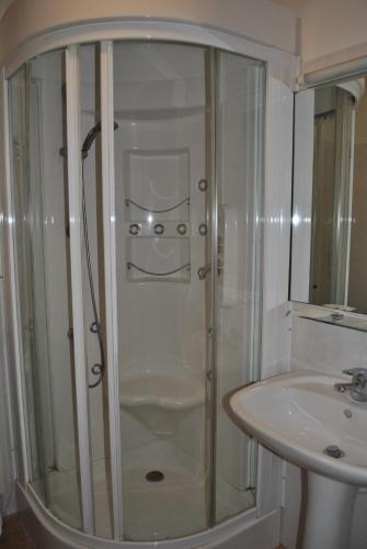 a shower with a glass door next to a sink at Albergo Al Viale in Trieste
