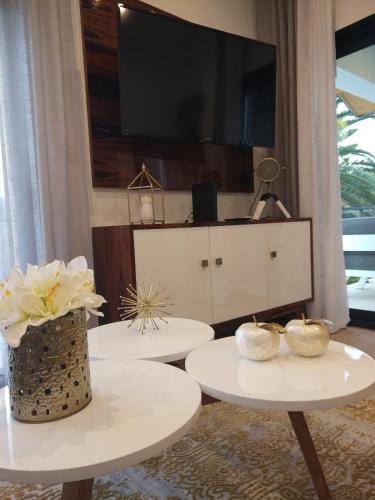 a living room with two white tables and a flat screen tv at Vistadouro 3 Style in Peso da Régua