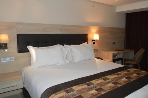 a hotel room with a large bed with white pillows at Anezi Tower Hotel in Agadir