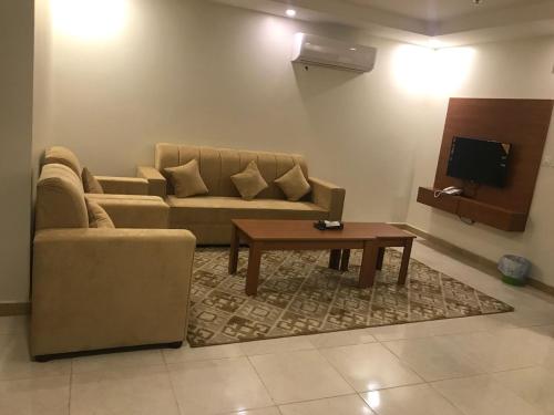 a living room with a couch and a coffee table at تاج الخليج للشقق المخدومة in Dammam