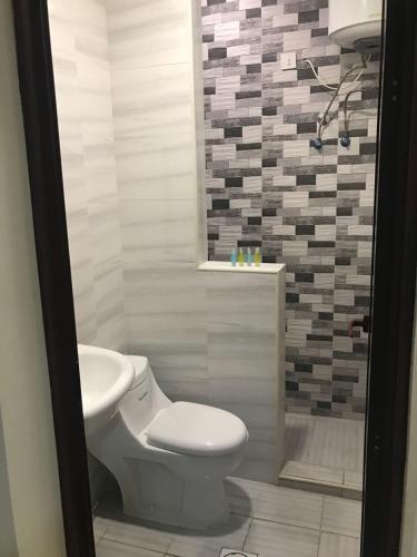 a bathroom with a toilet and a sink at تاج الخليج للشقق المخدومة in Dammam