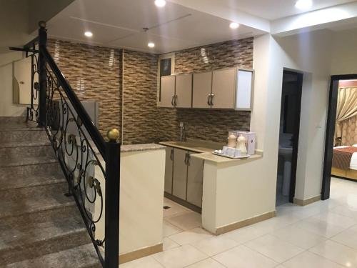 a kitchen with a staircase leading to a living room at تاج الخليج للشقق المخدومة in Dammam
