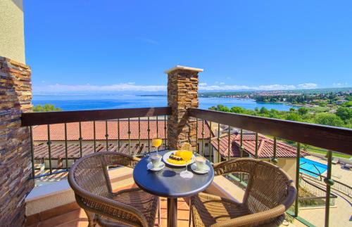 a patio with a table and chairs on a balcony at Blue Waves Resort in Malinska