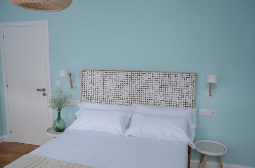 a bedroom with a bed with white pillows at A Casa dos Nores Charming House in Cangas de Morrazo