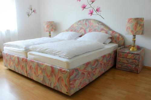 a bed in a room with two lamps and a table at Ferienwohnung Antes in Heppenheim an der Bergstrasse
