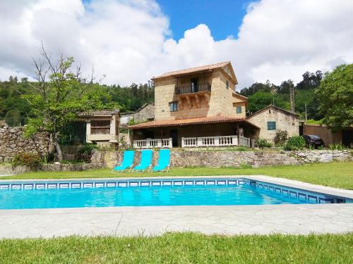 une maison avec une piscine en face d'un bâtiment dans l'établissement La Torre Mondariz, à Mondariz