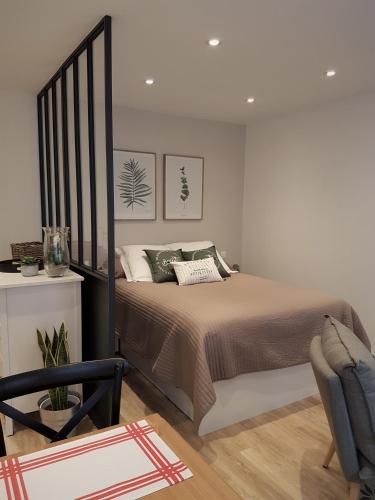 une chambre avec un grand lit et une chaise dans l'établissement La Bastido, à Arles