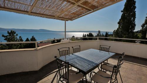 uma mesa e cadeiras numa varanda com vista para a água em Apartments Strmecki em Novi Vinodolski