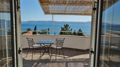 a table and chairs on a balcony with a view of the ocean at Apartments Strmecki in Novi Vinodolski