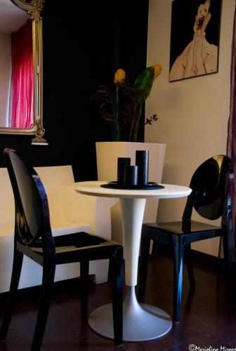 a table and two chairs with a white table and chairs at Eh13 Luxury Accommodation in Catania
