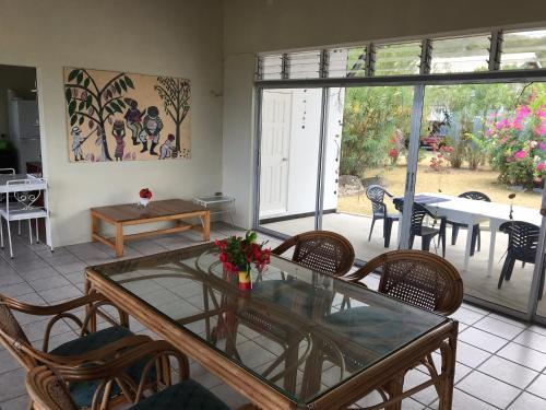 a dining room with a glass table and chairs at Garden Bungalow in Sauteurs