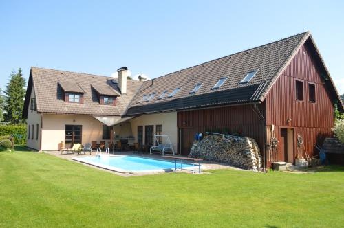 a large red barn with a pool in front of it at Penzion 409 in Horní Branná