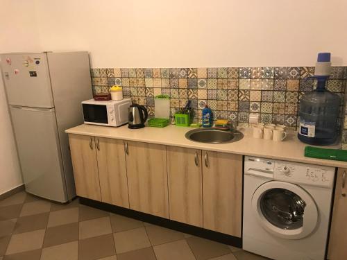 a kitchen with a sink and a refrigerator and a washing machine at FOX Hostel in Mykolaiv