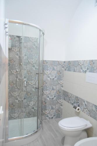 e bagno con servizi igienici e doccia in vetro. di Le Volte - Locazione Turistica a Terrasini