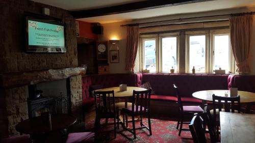 a restaurant with tables and chairs and a couch at The Rose and Crown in Huddersfield