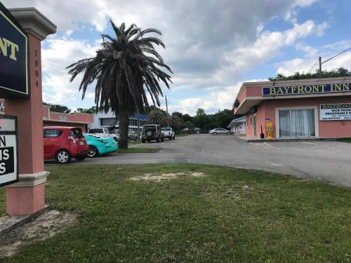 a parking lot with a palm tree and a car dealership at Bayfront Inn Biloxi in Biloxi
