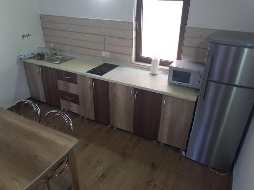 a kitchen with a stainless steel refrigerator and a sink at Cabana Soral Baile Figa in Beclean