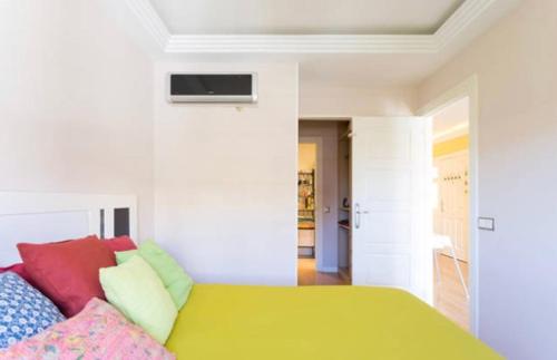 ein Schlafzimmer mit einem grünen Bett und bunten Kissen in der Unterkunft Holidays home in San Miguel de Abona