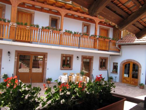 a courtyard of a house with a balcony at La Ferme de Louise in Hohengoeft
