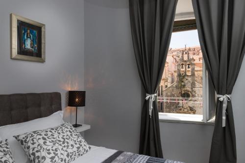 a bedroom with a bed and a window with a view at City Center Rooms in Dubrovnik