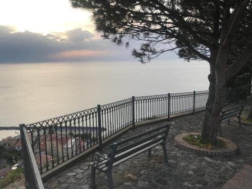 a bench sitting next to a fence near the water at Residenza Vinci Room & Suite in Pizzo