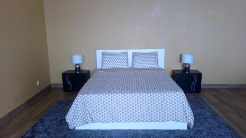 a bedroom with a bed with two pillows on it at Casa do Carvoeiro II-GOOD AND CHEAP!!! in São Vicente