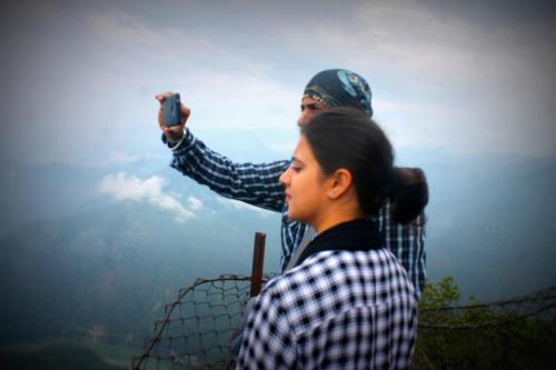 a man taking a picture of a woman behind a fence at Mansarover Home Stay in Kalimpong