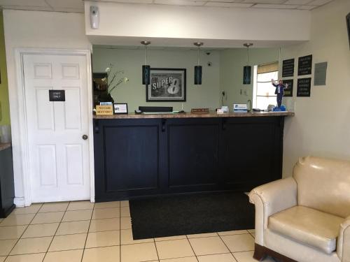 a bar in a room with a chair and a door at Super 8 by Wyndham Augusta in Augusta