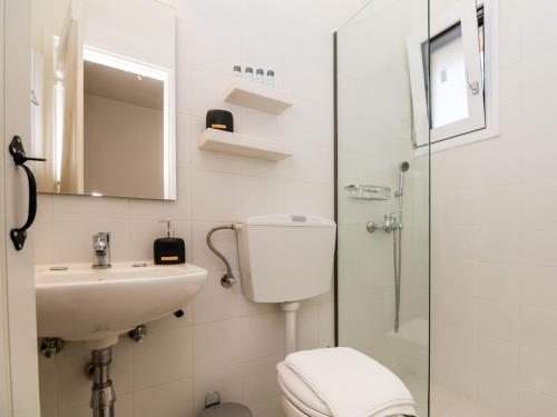 a bathroom with a toilet and a sink and a shower at Casa Buganvilla in Minia
