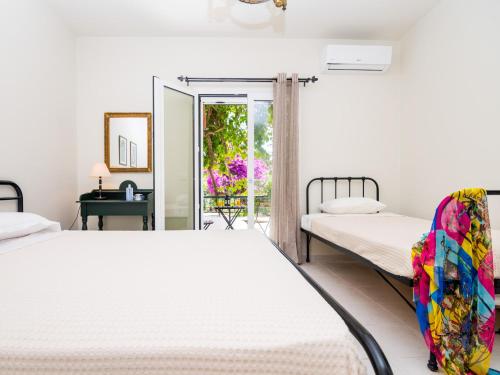 a bedroom with two beds and a balcony at Casa Buganvilla in Minia
