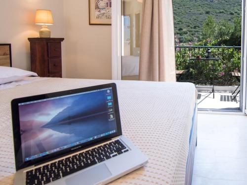 a laptop computer sitting on top of a bed at Casa Buganvilla in Minia