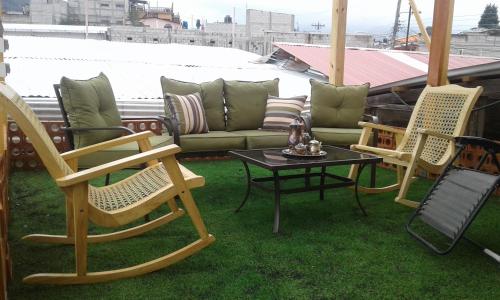 a patio with chairs and a couch and a table at Hotel Vintage "Casa las Flores" in Quetzaltenango
