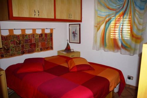 a bedroom with a bed with a colorful blanket at Casa Levanzo in Levanzo