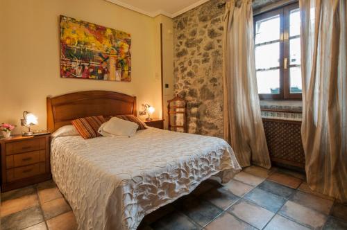 um quarto com uma cama grande e uma janela em Hostal Rural Elosta em Lekunberri