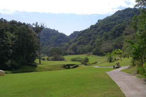 a golf course with a mountain in the background at Stay In CR Los Sueños Condos in Jacó