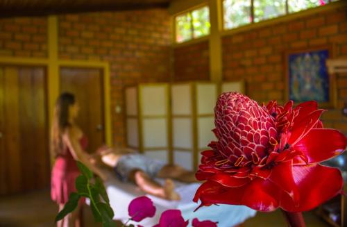 塔拉波托的住宿－Yacumaman Sanctuary，坐在床上的红花
