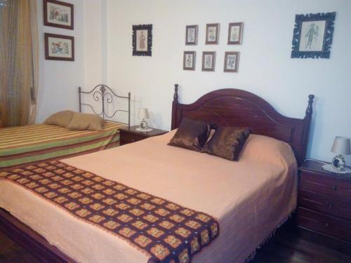 a bedroom with two beds and pictures on the wall at Casa de Praia da Lú in Figueira da Foz