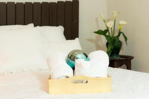 a wooden box with towels and a globe on a bed at Suite 5A, Altavista, Garden House, Welcome to San Angel in Mexico City