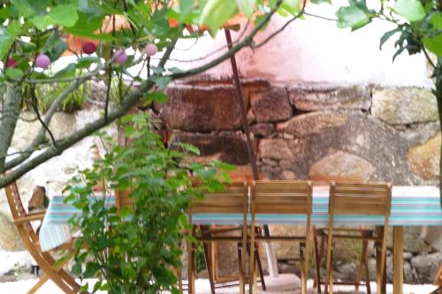 a table and chairs in front of a stone wall at Casa Portugueza Experience in Porto