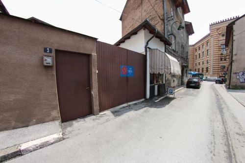 uma rua vazia ao lado de um edifício com uma porta castanha em Guest House Time Out em Saraievo
