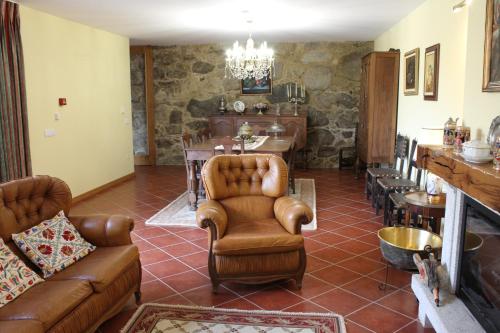 a living room with leather furniture and a table at Quinta do Toutuço in Arouca