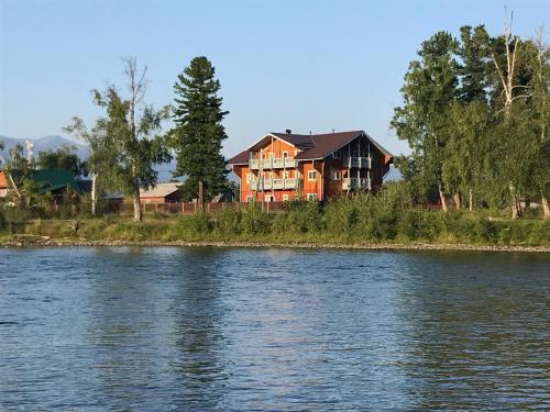 a large house on the side of a river at Usadba Novosnezhka in Novosnezhnaya