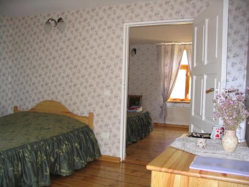 a bedroom with a bed and a table and a window at Saule in Talsi