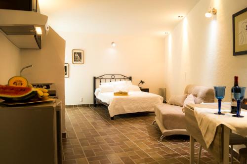 um quarto com uma cama e uma sala de estar com um sofá em Suite 5B, Cultura, Garden House, Welcome to San Angel em Cidade do México
