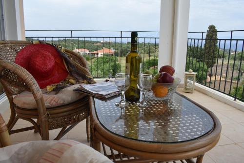 a table with a bottle of wine and glasses on a balcony at Garden Villas in Koroni