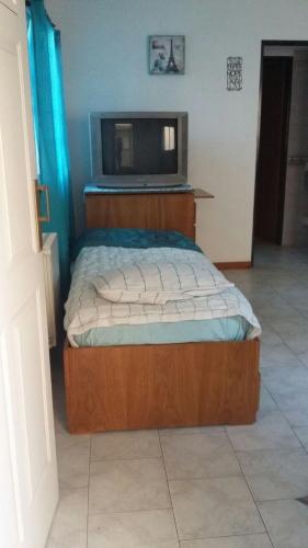 a bedroom with a bed with a tv on it at Departamento de Celina in Olavarría